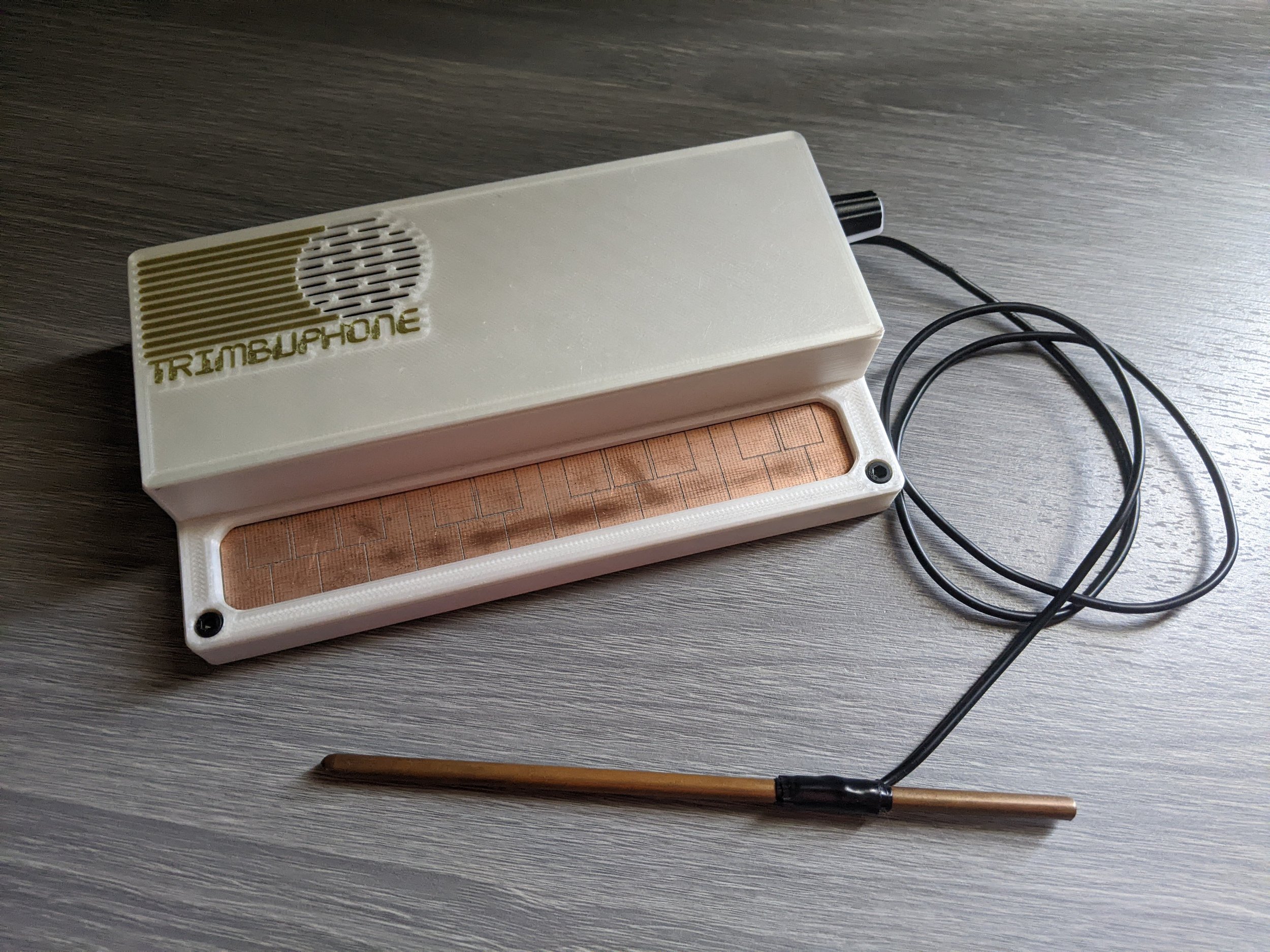 The finished Trimbuphone, a white machine with a wire-attached pen